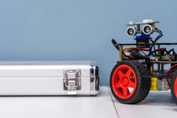 a toy car sitting next to a metal case